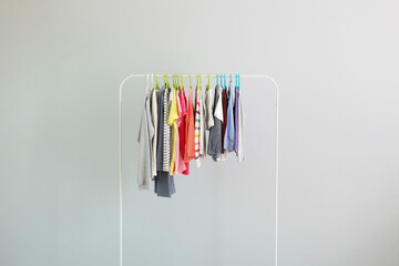 Wall Mural - Children clothes on a hanger on a colored background. Children's clothing, children's shopping.