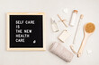 © netrun78 - Self care is the new health care. Motivational quote on black letter board with variety of organic body and face care products. Natural homemade eco friendly beauty products