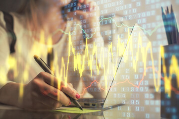 Double exposure of woman hands typing on computer and financial graph hologram drawing. Stock market analysis concept.