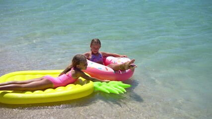 Wall Mural - Little girls having fun at tropical beach during summer vacation playing together