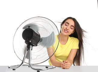 Canvas Print - Woman enjoying air flow from fan on white background. Summer heat