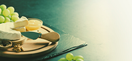 sliced brie cheese served with knife, banner