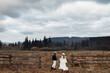 © shunevich - Handsome man and beautiful woman walking at the field, wearing hats, enjoy weekend together, loving husband gently hold a hand of adorable wife, fashionable couple concept