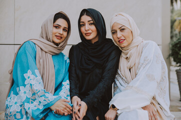 Wall Mural - Three women friends going out in Dubai. Girls wearing the united arab emirates traditional abaya