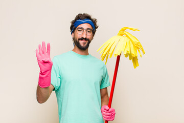 Wall Mural - young man smiling and looking friendly, showing number four or fourth with hand forward, counting down