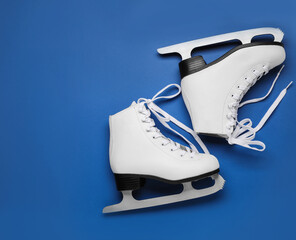 Wall Mural - pair of figure ice skates on blue background, flat lay. space for text