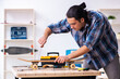 © Elnur - Young man repairing skateboard at workshop