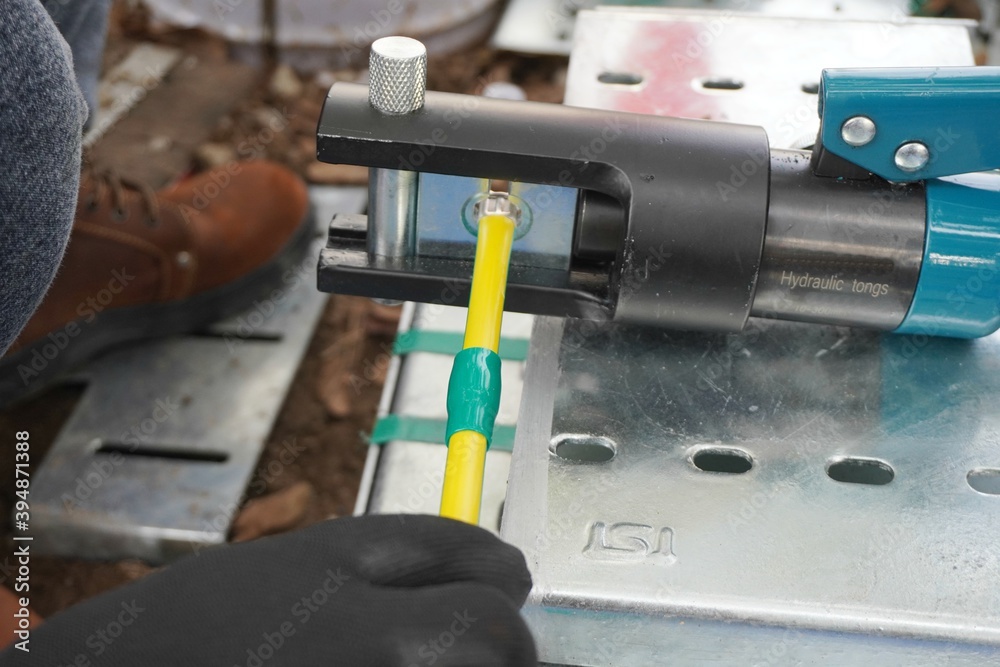 Hydraulic tongs crimping that is used by workers to crimp ground wires ...