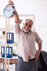 Old male employee doing physical exercises in time management co