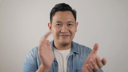 Wall Mural - Young Asian man looked happy and proud clapping gesture