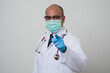 © Chanakon - Asian bald Doctor in white coat, stethoscope, blue glove wearing face mask.pointing finger into camera isolated on white background.
