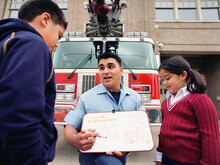 Fireman Talking About Evacuation Routes To Children