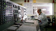 © SuperStock - Senior engineer taking phone instructions whilst monitoring controls in ship's engine room.