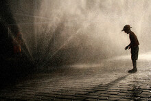 Silhouette Boy Playing On Street During Rainfall