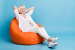 © deagreez - Full length body size photo of smiling granny resting relaxing closed eyes sitting in beanbag isolated on vibrant blue color background