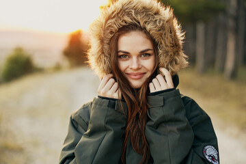 smiling woman in a hood close-up in nature cropped view