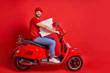 Nice Caucasian Male Guy Driving Moped Motorcycle Bringing Pile Stack Pizza Order, Delivery Male Is In A Hurry To Deliver Orders Isolated Over Red Color Background