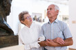 © caftor - mature European couple examines paintings in an exhibition in hall of art museum