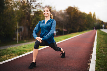 Wall Mural - Beautiful adult woman is exercising outdoor on cloudy day in autumn.