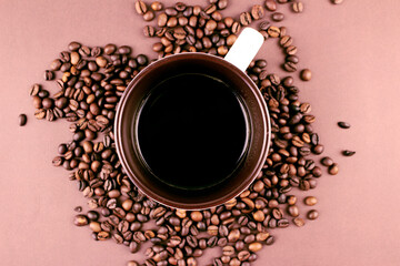 Mug with coffee on brown background with roasted coffee beans