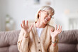© JenkoAtaman - Cheerful mature woman laughing at home.