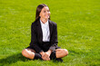 © deagreez - Photo of small schoolgirl sit lawn green grass look side relax crossed legs wear black uniform socks urban city outdoors