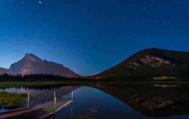 Wall Mural - Vermilion Lakes Viewpoint at night, Full of stars above Mt Rundle, starry sky reflected in the water surface. Beautiful landscape in Banff National Park, Canadian Rockies, Alberta, Canada.