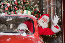 Santa Claus Greeting While Driving A Red Retro Car. Merry Christmas