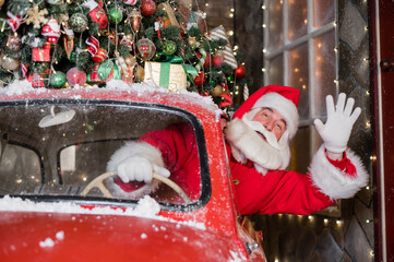 Santa claus greeting while driving a red retro car. Merry Christmas