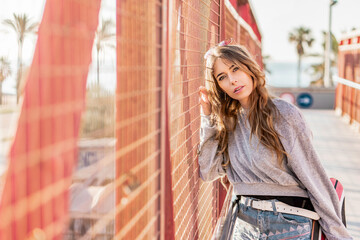 Skater girl model posing with a longboard. Red concept. California style fashion. Woman and skateboard. Urban portrait