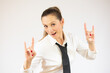 © Danko - Beautiful business woman over isolated background shouting with crazy expression doing rock symbol with hands up. Music star. Heavy concept.