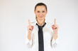 © Danko - Smiling business woman pointing up and looking at the camera over white background