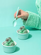 Aqua scene of hand holding a spoon to eat mint icecream