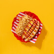 Tasty New York hotdog served in a red dish over a yellow background