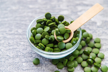 Green pills of chlorella and spirulina. Selective focus