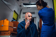 © Anna Kosolapova - An EMT talking to her patient, who is sitting in an ambulance.