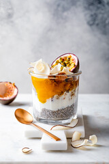 Wall Mural - Healthy tropical fruit chia pudding with granola, mango, passion fruit and coconut chips in a glass jar. Vegan healthy breakfast, clean eating.