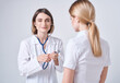 © SHOTPRIME STUDIO - doctor in a medical gown on a light background and a blond woman patient