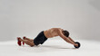 Muscular sportsman exercising with fitness ab roller