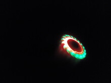 Close-up Of Illuminated Fidget Spinner Spinning Against Black Background