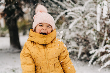 Wall Mural - Toddler girl happy with snow day in winter. Playing outside on Christmas holiday