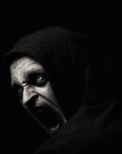 Portrait Of Scary Man Shouting Against Black Background