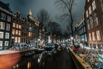 Wall Mural - Amsterdam night city water canal with evening lights reflection and old houses, Amsterdam, Netherlands.