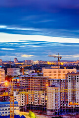 New Construction Site with Building Cranes Against Night Sky. Picture Taken At Blue Hour