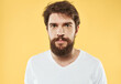 © SHOTPRIME STUDIO - A man with a beard and mustache on a yellow background and a white T-shirt