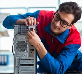 Computer repairman working on repairing computer in IT workshop