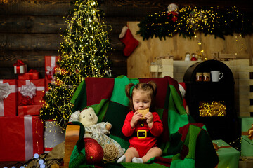 Wall Mural - Little baby in Santa hat eat Christmas cookies.