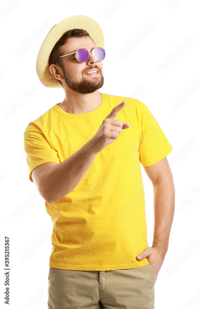 Handsome man with stylish sunglasses showing something on white background