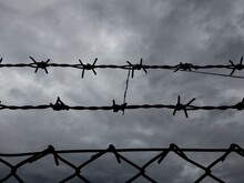 Low Angle View Of Barbed Wire Against Cloudy Sky