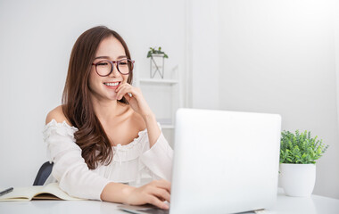 Portrait of smiling beautiful business asian nerdy woman working in office desk virtual computer. Small business people employee freelance online sme marketing e-commerce telemarketing concept